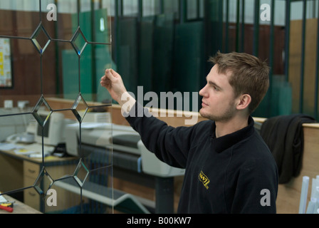 Factory worker inspecting leaded glass in glass factory Stock Photo