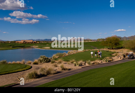 Golfers playing the 18th hole on the Tournament Players Club golf course in tourist area of Scottsdale Phoenix Arizona USA Stock Photo