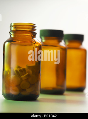 Opened bottle of pills with empty bottles in line Stock Photo