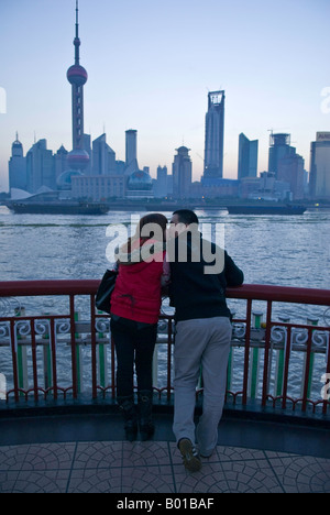 Young couple kiss and cuddle along skyline, The Bund, Shanghai, China Stock Photo