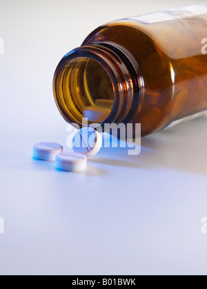 Capsules spill out of an open bottle, white background Stock Photo