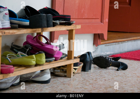 Group of shoes piled up outside entrance to temple in Singapore Stock Photo