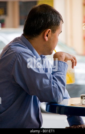 Handsome Asian man sitting down at restaurant in Singapore Stock Photo