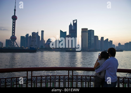 Young couple kiss and cuddle along skyline, The Bund, Shanghai, China Stock Photo