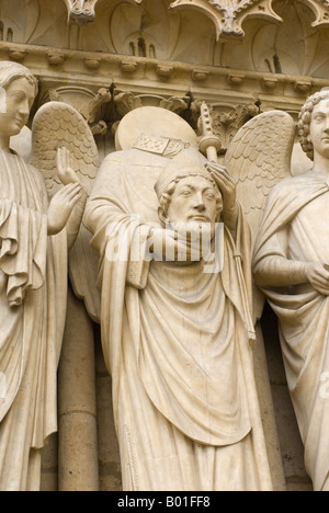 Relief statue on Notre Dame cathedral of St Denis holding his head Paris France Stock Photo