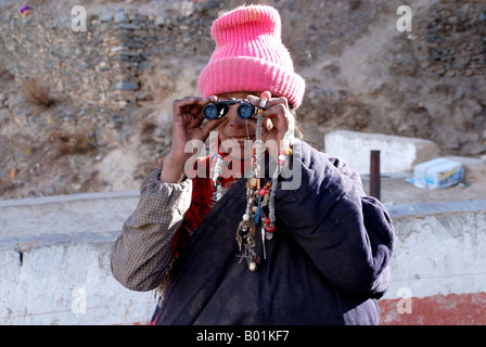 A happy tibetan woman use binoculars Stock Photo