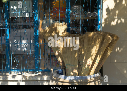 Old fashioned floor brooms for sale outside the village shop in Peristerona, near Polis, Paphos Region, Cyprus Stock Photo