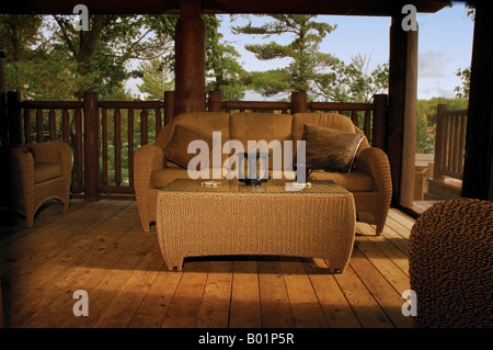 A well lite couch on the enclosed porch of a northern cottage Stock Photo