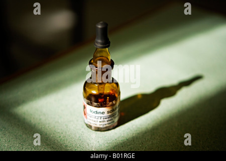 Iodine solution in brown glass dropper bottle on formica work surface in sunlight Stock Photo