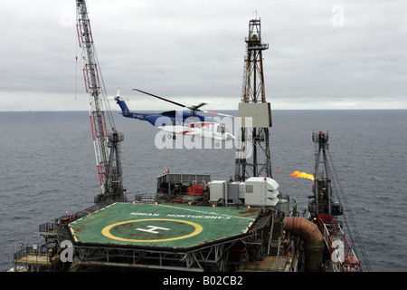 A Bristows S-92 helicopter takes off from an oil rig in the North Sea off the coast of North East Scotland Stock Photo