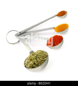 Assorted spices in metal measuring spoons on white background Stock Photo