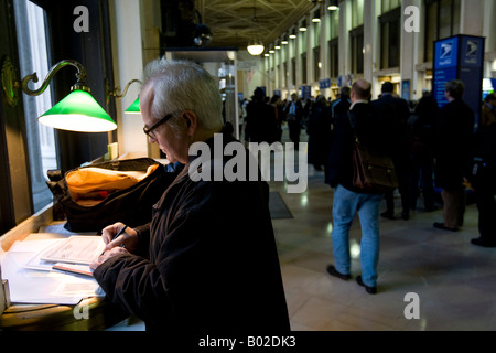 A man fills in his tax form in the lobby of the Farley Post Office in New York 15 April 2008 Stock Photo