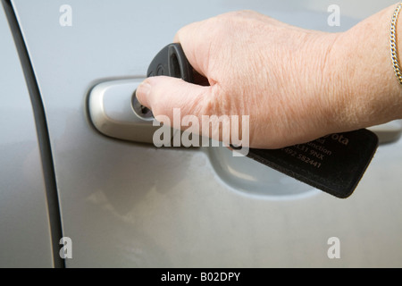 Still Life Studio Close up A woman s hand opening a car door with a key Stock Photo