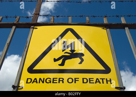 british sign on a fence warning of danger of death by electrocution, located in kingston upon thames, surrey england Stock Photo