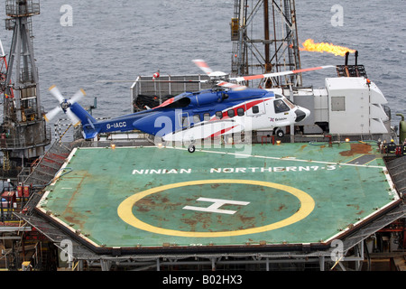 A Bristows S-92 helicopter lands on an oil rig in the North Sea off the coast of North East Scotland Stock Photo