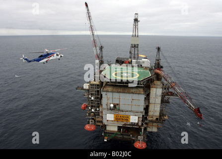 A Bristows S-92 helicopter lands on an oil rig in the North Sea off the coast of North East Scotland Stock Photo