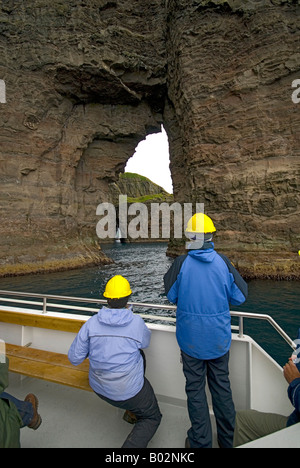 Tourist boat viewing the bird cliffs of south west Vagar, Faroe Islands Stock Photo