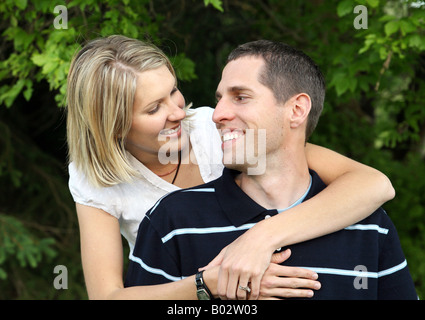 Young white married couple holding each other outdoors Stock Photo