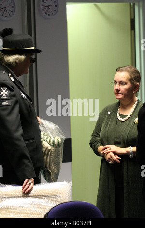 A tall lady in a St John Ambulance senior officer's uniform chat's with a shorter lady in a dark green dress Stock Photo