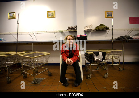 Bored woman in public laundry room waiting for laundry to get done.  Typical scene from Brooklyn public laundry place.  Brooklyn Stock Photo