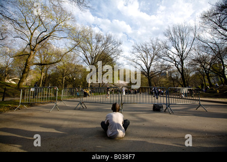 Boy observes people rollerskating and dancing to the music in Central Park, Manhattan, NY, USA. Stock Photo