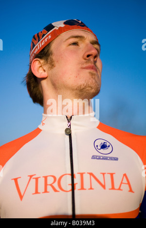 College aged young male cyclist portrait in team kit  jersey with blue sky background Stock Photo