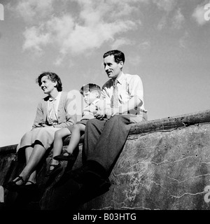 OLD VINTAGE FAMILY SNAPSHOT PHOTOGRAPH OF MARRIED COUPLE WITH YOUNG SON SITTING ON WALL ON HOLIDAY