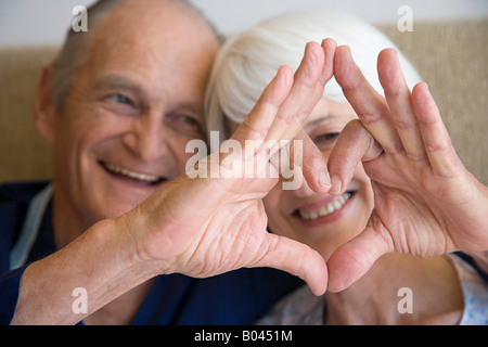 A couple making a heart shape with their hands Stock Photo
