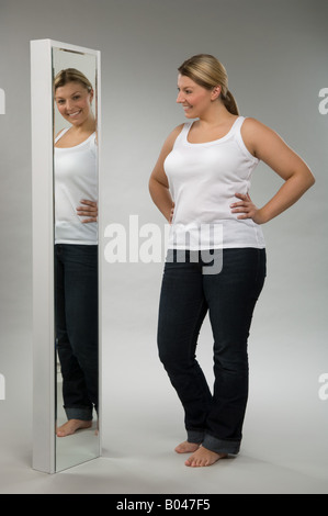 A woman looking in a mirror Stock Photo