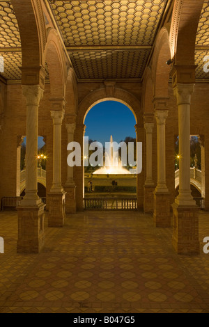 View of the fountain from the central building in Plaza de Espana, Parque Maria Luisa, at dusk in the City of Sevilla Stock Photo