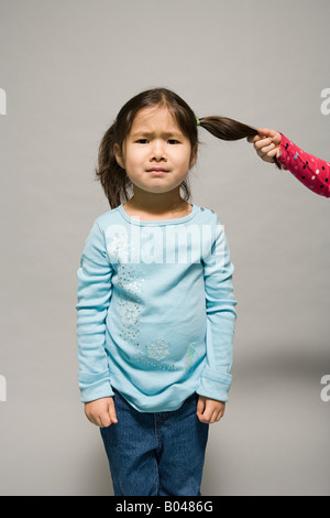 Girl having hair pulled Stock Photo - Alamy