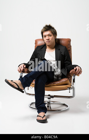 Japanese man sitting on a leather armchair Stock Photo