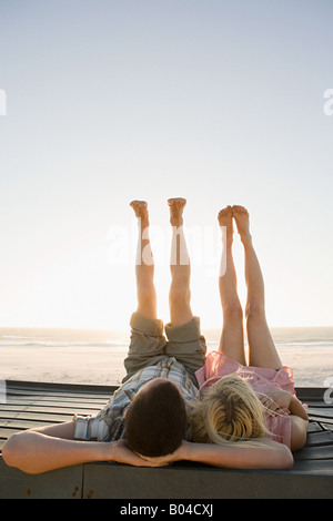 A couple lying down with their feet in the air Stock Photo