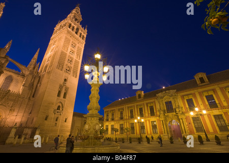 Seville Cathedral and La Giralda, a UNESCO World Heritage Site, seen from the Plaza Virgen de los Reyes at dusk Stock Photo