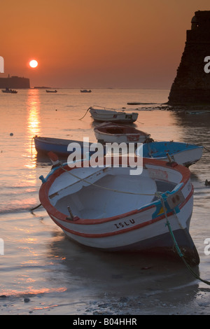 Small fishing boats anchored at Playa de la Caleta at sunset in the City of Cadiz, Province of Cadiz, Costa de la Luz, Andalusia Stock Photo