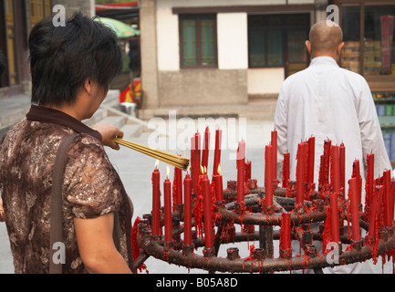 Woman Lighting Incense At Dacien Si Temple, Xian, China Stock Photo