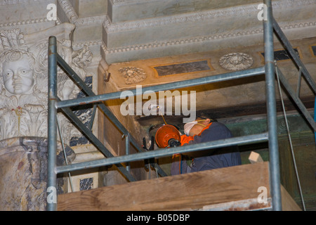 Construction worker restoring details at the main entrance to the Pisa Duomo (cathedral), a UNESCO World Heritage Site Stock Photo