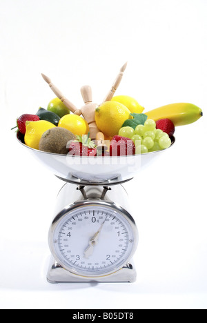 jointed doll between fruits in scale Stock Photo