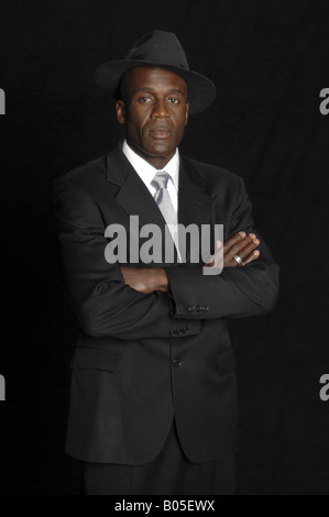 Half body portrait of a mid adult African American businessman in a white shirt, tie standing with his arms crossed Stock Photo