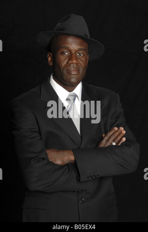 Half body portrait of a mid adult African American businessman in a white shirt, tie standing with his arms crossed Stock Photo