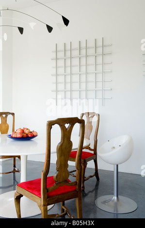 Tulip dining and Queen anne chairs in contemporary factory conversion Stock Photo