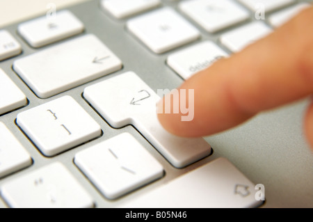 Finger on keyboard enter key Stock Photo