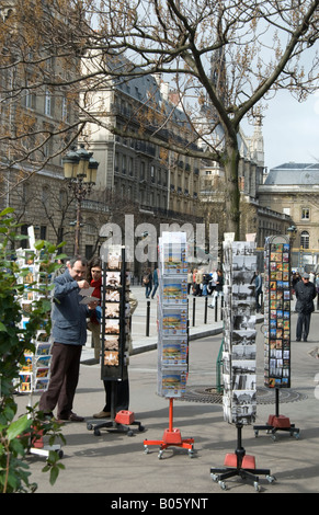 A couple of tourists browsing racks of postcards at a souvenir stand in Paris, France. Stock Photo