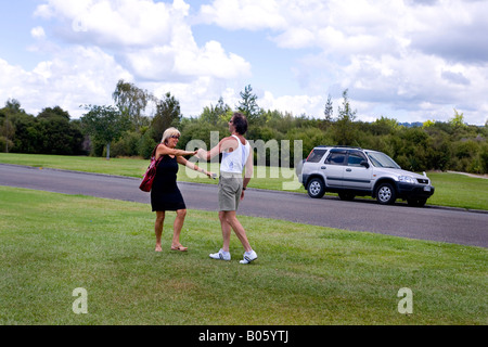 Couple ceroc dancing on the grass next to their car, New Zealand Stock Photo