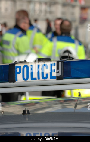 A police car roof light sign with distant out of focus police officers. Picture by Jim Holden. Stock Photo