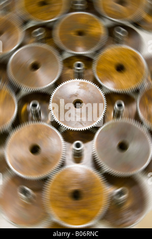 Stationary gear surrounded by spinning gears Stock Photo