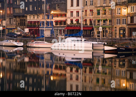 French harbour night time reflections of moored boats in the Honfluer Vieux Bassin at twilight. Stock Photo