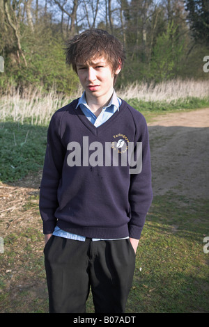 Teenage boy looking casual in his navy blue school uniform in countryside Stock Photo