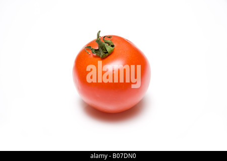 Red tomato isolated on a white studio background. Stock Photo