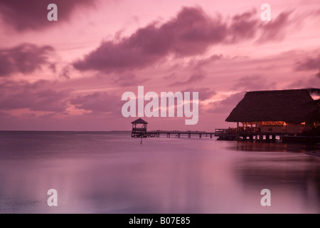 Belize, Placencia, People in beach bar near the Moorings at sunset Stock Photo